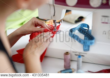 Woman Sew On Red Fabric On A Sewing Machine