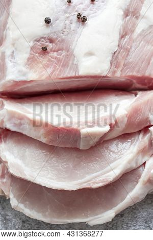 Piece Of Raw Pork On A Gray Background. Fresh Meat Is Ready To Cook. View From Above