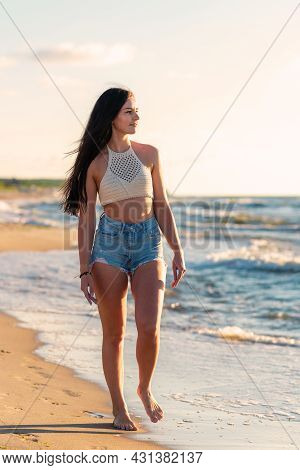 Lonely Young Woman Walking On The Beachsunset Day.beach Woman In Fashion Beachwear Relaxing Walking 
