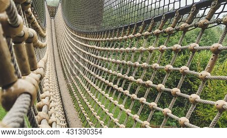 Suspension Bridge With Rope And Mesh Nett On A Playground For Children. Outdoor Fun.