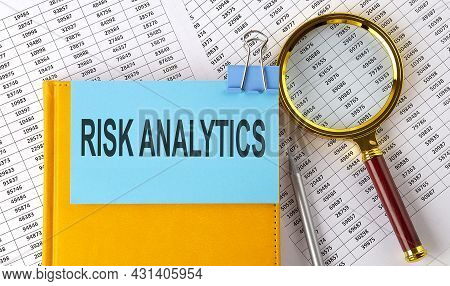 Risk Analytics Text On Sticker On Notebook With Magnifier And Chart. Business