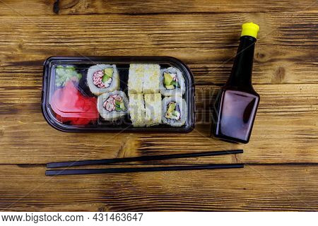 Uramaki Sushi Rolls With Surimi In Plastic Box On Wooden Table. Top View. Sushi For Take Away Or Del