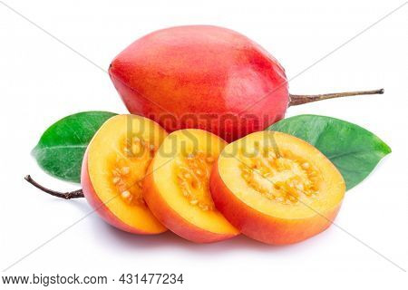 Ripe tamarillo fruits with slices and tamarillo leaves isolated on a white background.