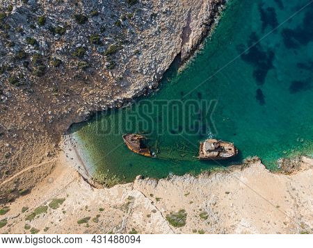 aerial drone view of Shipwreck Olympia boat in Amorgos island during summer holidays, at the coastal rocky area, people on the beach, Cyclades, Greece. Travel background