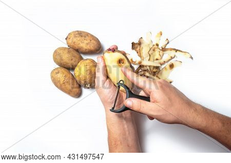 The Guy Peels Potatoes On A White Background, In The Hands Of A Rotten Potato
