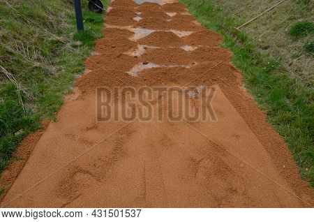 Compressing The Gravel Of The New Park Threshing Path. Lawn Seed Is Repaired By Rolling A Metal Hand