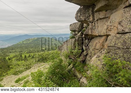 Large Kurum Stones Lie In The Forest In The Mountains, Stones Covered With Moss, Against The Backgro