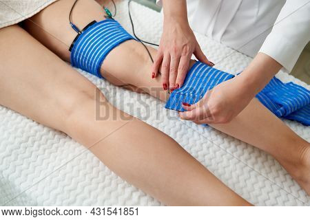 The Procedure Of Myostimulation On Legs Of A Woman In A Beauty Salon. Caring For The Body With Elect