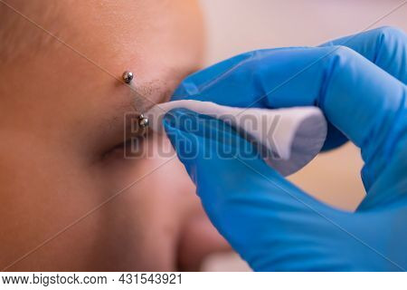 Man With Pierced Eyebrow. Three Small Black Piercings.