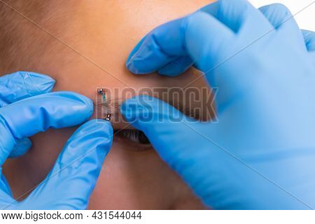 Man With Pierced Eyebrow. Three Small Black Piercings.