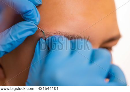 Man With Pierced Eyebrow. Three Small Black Piercings.