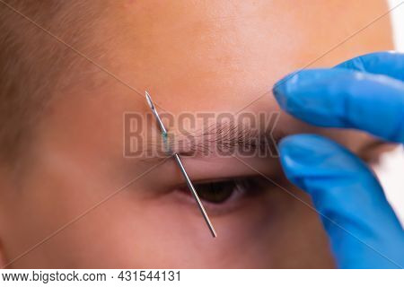 Man With Pierced Eyebrow. Three Small Black Piercings.