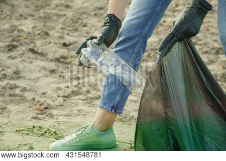 Volunteer Woman Puts A Plastic Bottle In A Trash Bag. Garbage Collection In The Forestor Nature.