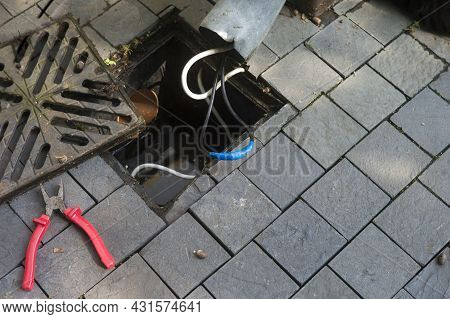 Overflown Storm Drain And Insulated Wire After Short Circuit, Outdoor Shot
