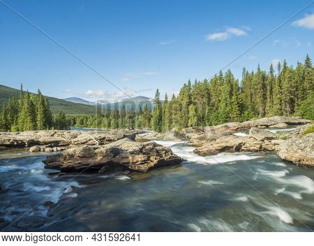 Beautiful Landscape With Long Exposure Water Stream And Cascade Of River Kamajokk, Boulders And Spru