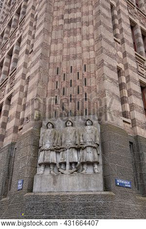 Amsterdam, Netherlands - August 13, 2021: Gray Statue-fresco Of 3 Sailors Holding Anchor At Basse Of