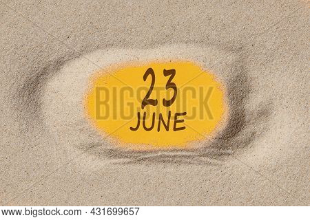 June 23. 23th Day Of The Month, Calendar Date. Hole In Sand. Yellow Background Is Visible Through Ho