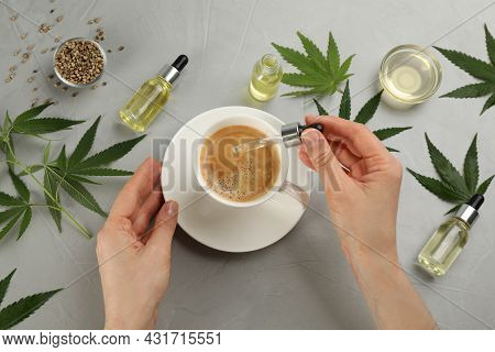 Top View Of Woman Dripping Thc Tincture Or Cbd Oil Into Coffee At Light Grey Table, Closeup