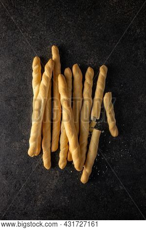 Grissini sticks. Traditional italian bread sticks on black table. Top view.