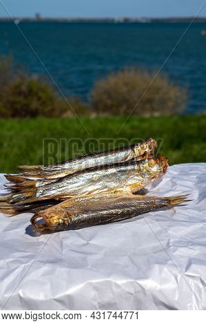 Smoked Sprattus Or Sprats Sea Fish Served Outdoor With View On Blue Sea Water