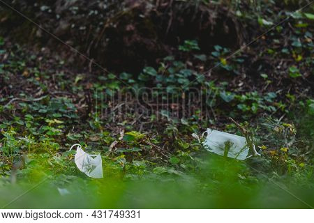 Close Up Picture Of Two Medical Masks Thrown To The Ground In The Park After Using Them By People, C
