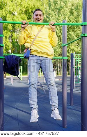A Young Man Pulls Himself Up On A Horizontal Bar. Strength Training. Healthy Lifestyle. Vertical Pho