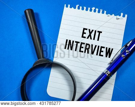 Business Concept.text Exit Interview Writing On Notepaper With Pen And Magnifying Glass On Blue Back