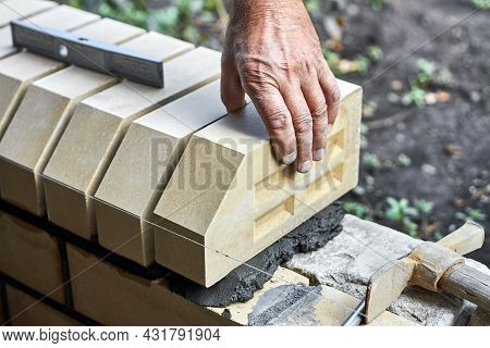 Bricklayer Installing Bricks On The New Fence From Facing Bricks.