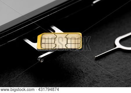 Sim Card, Mobile Phone And Ejector On Black Table, Closeup