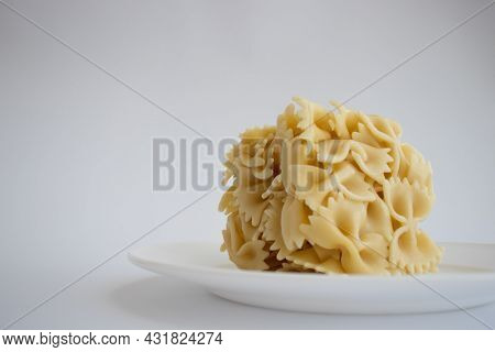 Farfalle Cooked Farfallini Pasta In A Shape Of Cube On A White Plate.