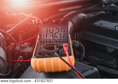 Voltage Of The Car's Starter Battery Is Measured By A Multimeter. Voltage Is About 14 Volts When The