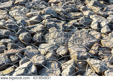 Retaining Wall Gabion On Hill Slope, Wire Basket Filled With Granite Stones. Rocks Under Wirework Me