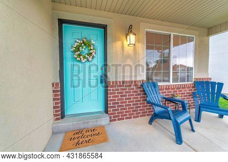 Porch Of A House With Blue Lounge Chairs And Wall Lamp