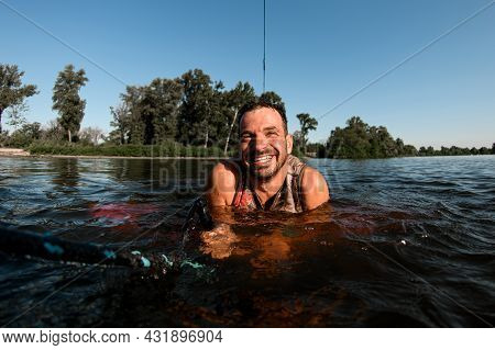 Close-up Of Smiling Adult Man Holding A Rope In The Water