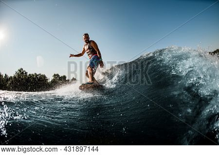 Man Ride Down On Splashing River Wave On Foilboard At Summer Day