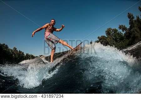 Active Guy On Foilboard Balancing On Wave Against The Background Of Blue Sky.