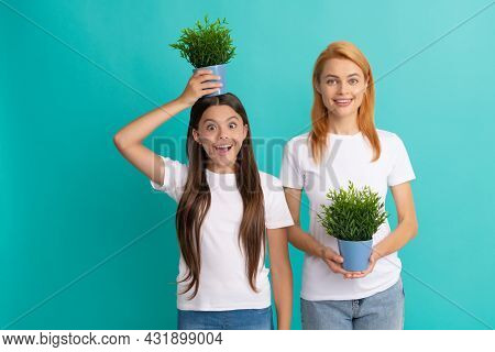 Family Of Mother And Surprised Girl Child Holding Pot Plant On Head To Grow Taller, Growing