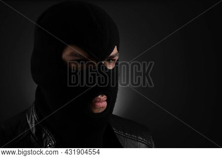 Man Wearing Knitted Balaclava On Black Background, Space For Text