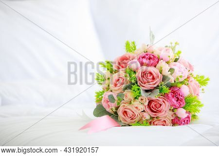 A Bouquet Bunch Of Colorful Fake Fabric Flowers On White Bed Cover With Copy Spce.