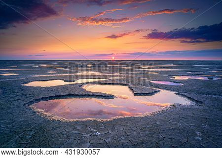 Wadden Sea In The Netherlands During Sunset With Wid Angel View And Colorful Clouds.