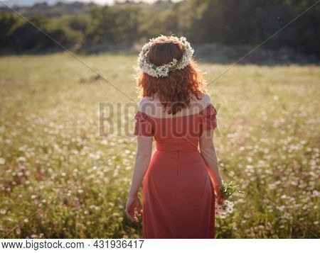 Red-haired Woman On A Field On A Summer Evening