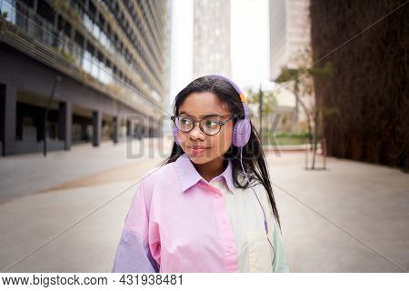 Portrait Of Young African American Wearing Glasses Listening Music With Headphones On Urban Backgrou