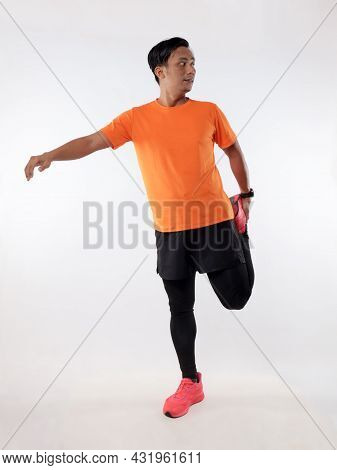 Asian Male Runner Warming Up Prepararing His Body Before Running Workout. Stretch His Leg Muscle, St