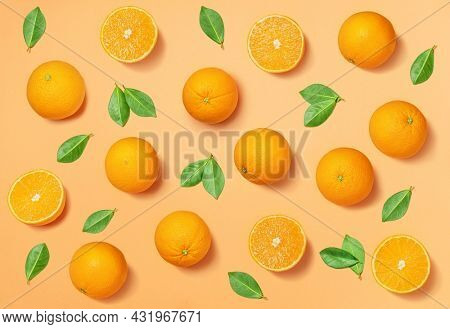 Fruit pattern arranged of oranges and orange leaves on yellow background. Lay out background.