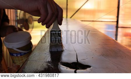 A Varnisher Covers The Textured Surface Of Furniture With Varnish From A White Can Using A Narrow Br