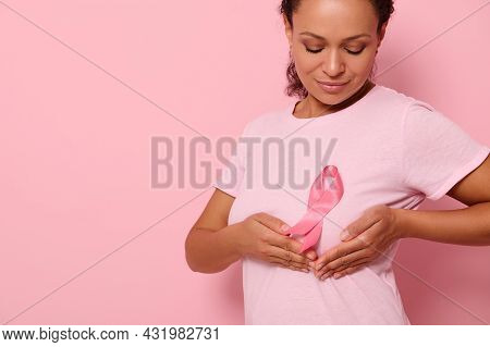 African American Woman Puts Hands Under Pink Ribbon On Her Pink T Shirt, For Breast Cancer Campaign,