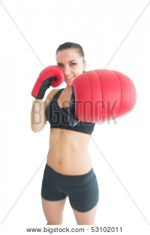 Attractive cheerful woman wearing red boxing gloves on white background