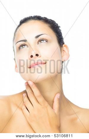 Front view of day dreaming beautiful woman looking upwards touching her throat 