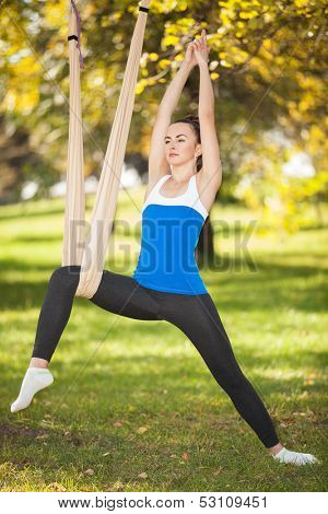 Anti-gravity Yoga, woman doing yoga exercises in the park
