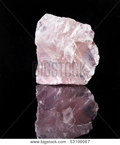 Natural Rose Quartz crystal with reflection on black surface background